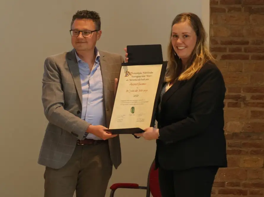 Foto van Astrid Eeuwes die de Dr. J. van der Biltprijs uitgereikt krijgt.