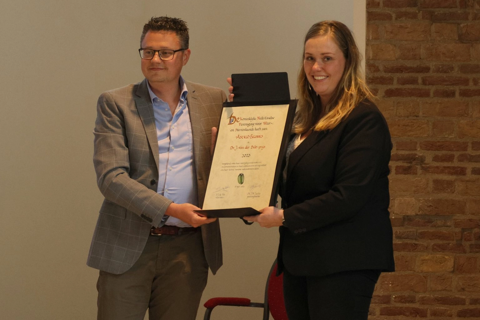 Foto van Astrid Eeuwes die de Dr. J. van der Biltprijs uitgereikt krijgt.