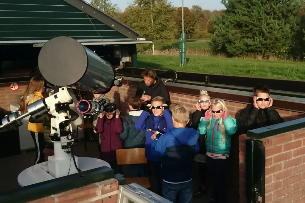 Foto van leerlingen bij een telescoop.
