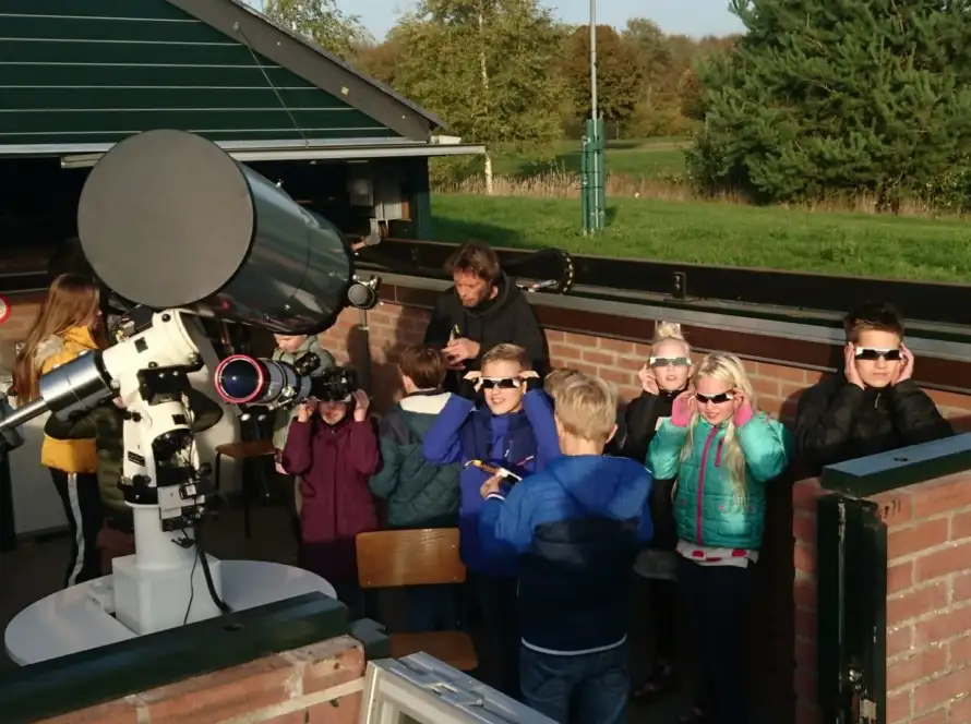 Foto van leerlingen bij een telescoop.