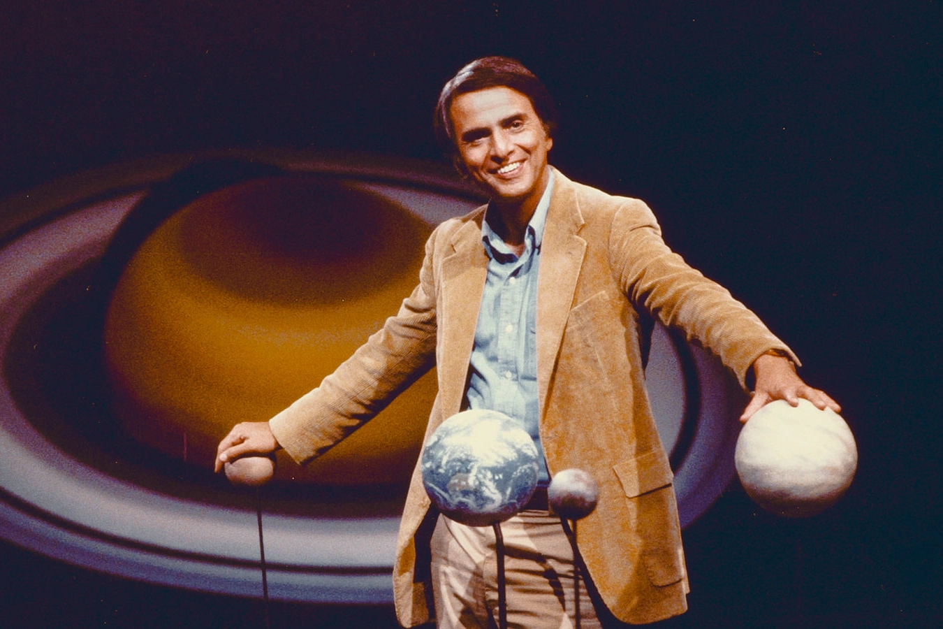 Portret van astronoom en wetenschapscommunicator Carl Sagan tegen een kosmische achtergrond.