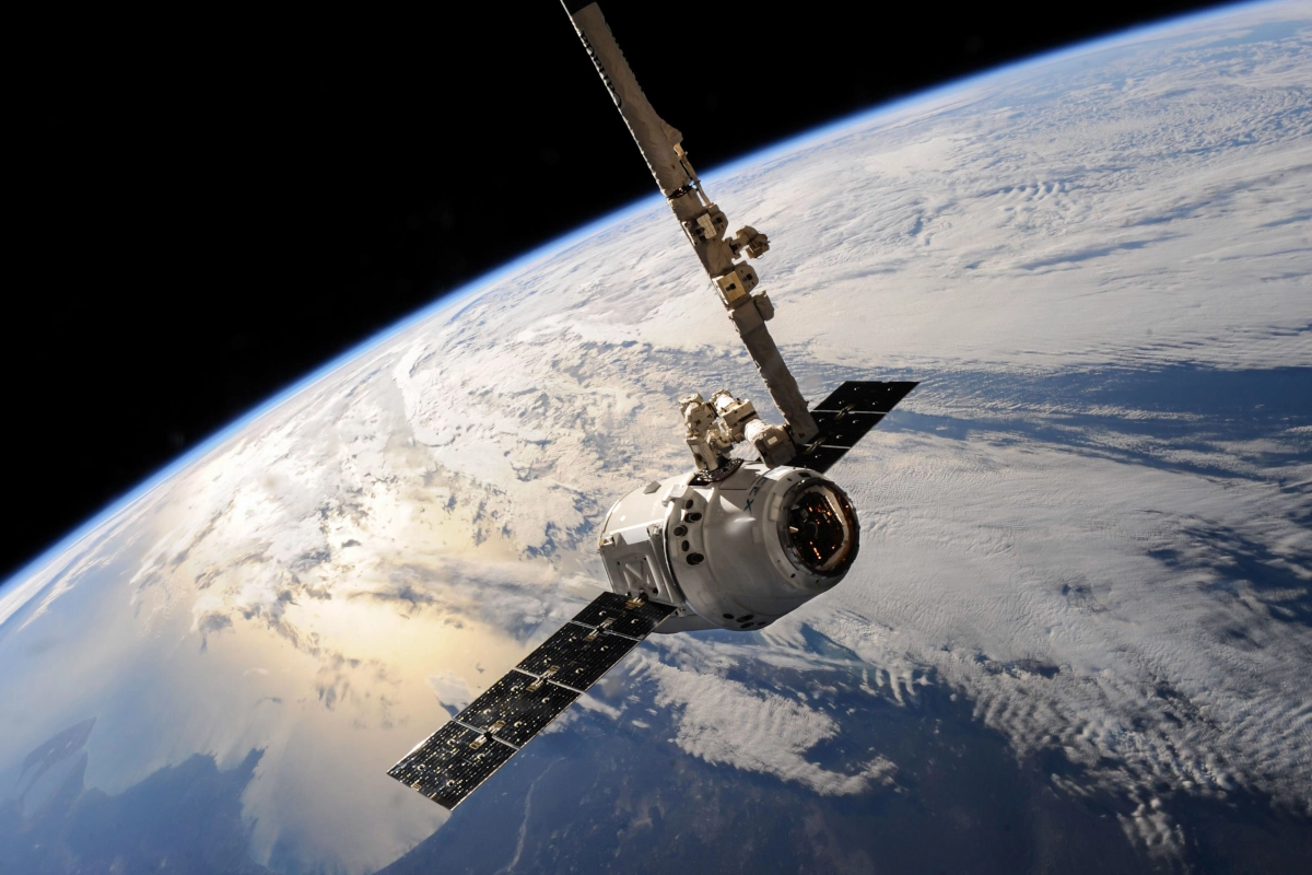 Een satelliet glijdt over de aarde en toont spectaculaire wolkenformaties en de immense uitgestrektheid van de ruimte.